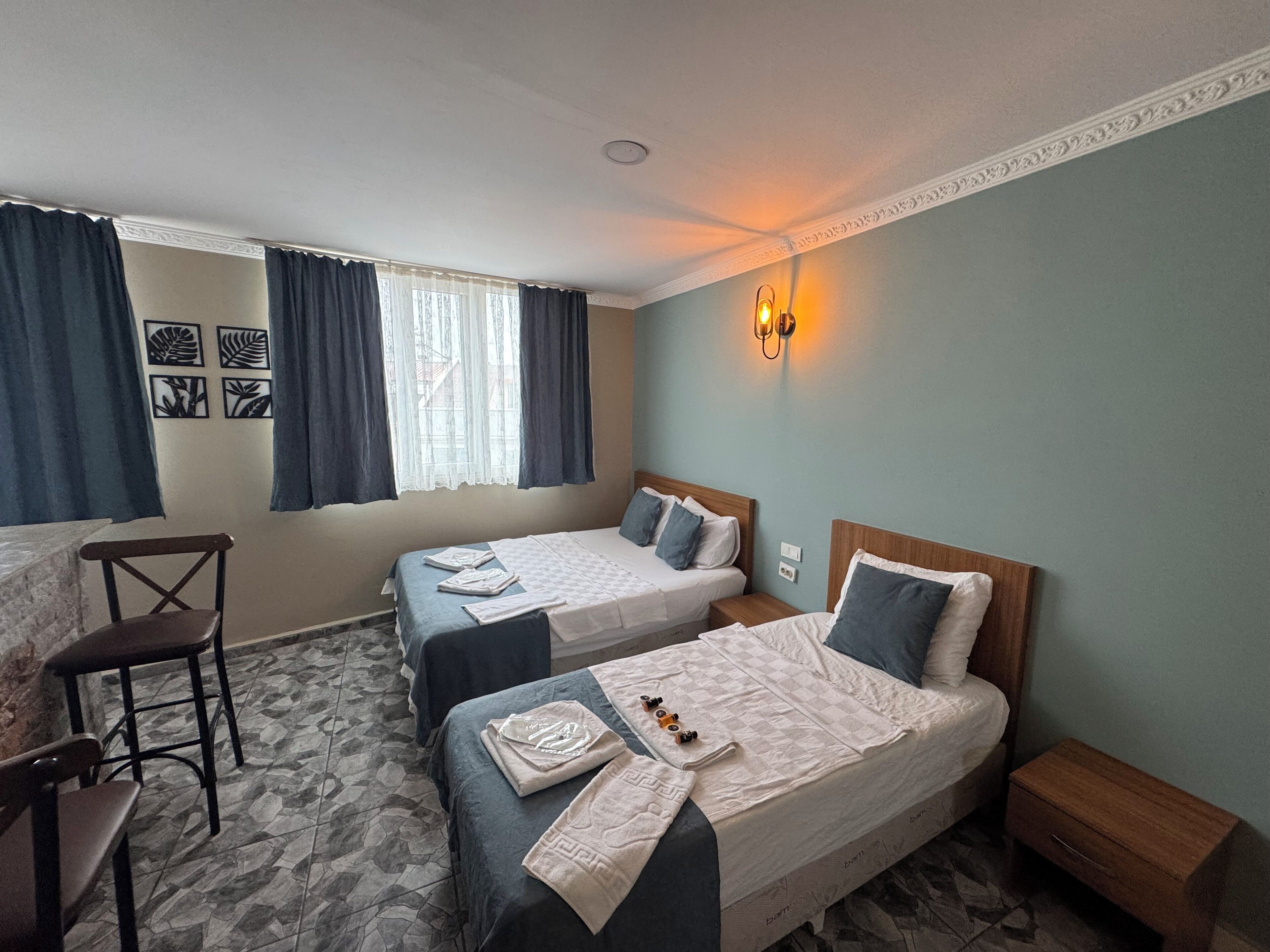 A hotel room with two beds, a desk, and a chair.