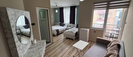 Una habitación de hotel moderna con un tocador de mármol, un sofá, una mesita y dos camas.