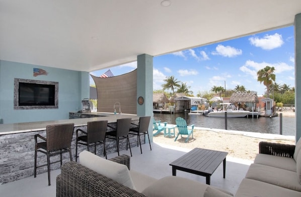 A covered outdoor area with a bar, seating, and a view of a marina.