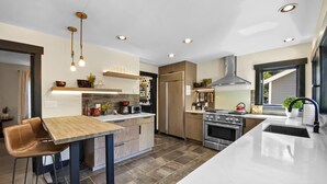 Una cocina moderna con una isla central, horno empotrado y electrodomésticos de acero inoxidable.