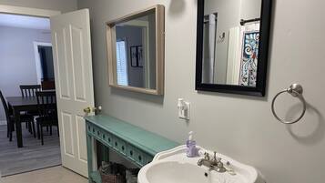 Een bad/douchecombinatie, een haardroger, handdoeken, zeep