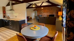 A modern kitchen with a dining area. - New - Luxury Spacious Apartment in Beautiful Grounds (Oswestry, Shropshire)