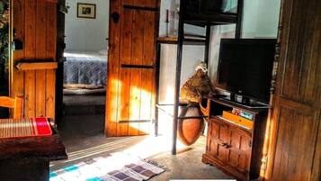 Una stanza rustica con mobili in legno, una televisione e un vaso grande.