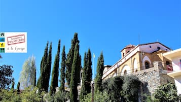 Un edificio con facciata in pietra, finestre ad arco e un balcone.