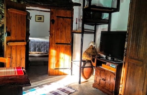 Una habitación rústica con muebles de madera, un televisor y un jarrón grande.