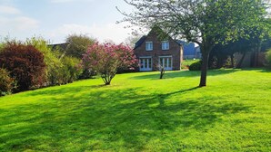 A house with a well-maintained lawn and flowering bushes. - Gîte la bocagere  (Autreppes)