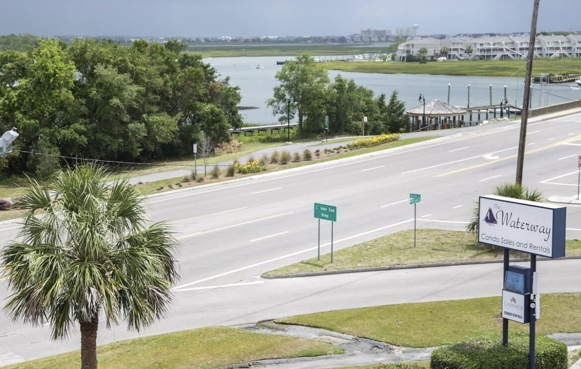 A road intersection with a sign for 'Waterway Condo Sales and Rentals'.