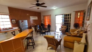 A kitchen with a bar area, dining chairs, and a sofa. - Private Guest Villa - Two Bedroom - Full Kitchen - Ocean Front Villa Cozumel (San Miguel de Cozumel)