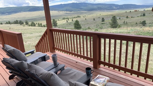 Eine Terrasse mit Sitzgelegenheiten, einem Buch und einer Tasse.