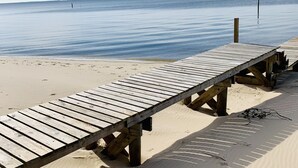 Un muelle de madera que se adentra en aguas tranquilas bajo un cielo despejado.
