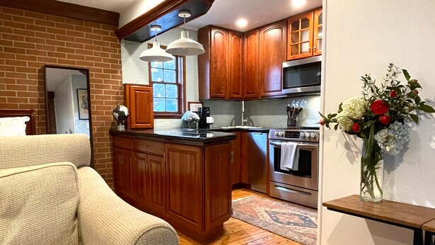 A kitchen with wooden cabinets, a stainless steel oven, and a large island.