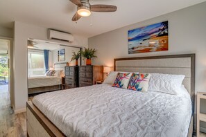 Une chambre dotée d’un grand lit, d’un ventilateur de plafond, d’un climatiseur, d’un tableau et offrant une vue sur l’extérieur.