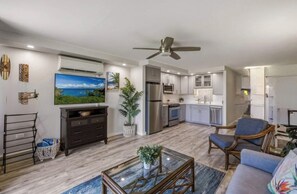 A modern living room with a sofa, coffee table, and a ceiling fan.