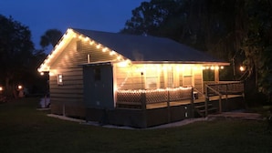Un petit bâtiment d’un seul étage, doté d’un porche et décoré de guirlandes lumineuses.