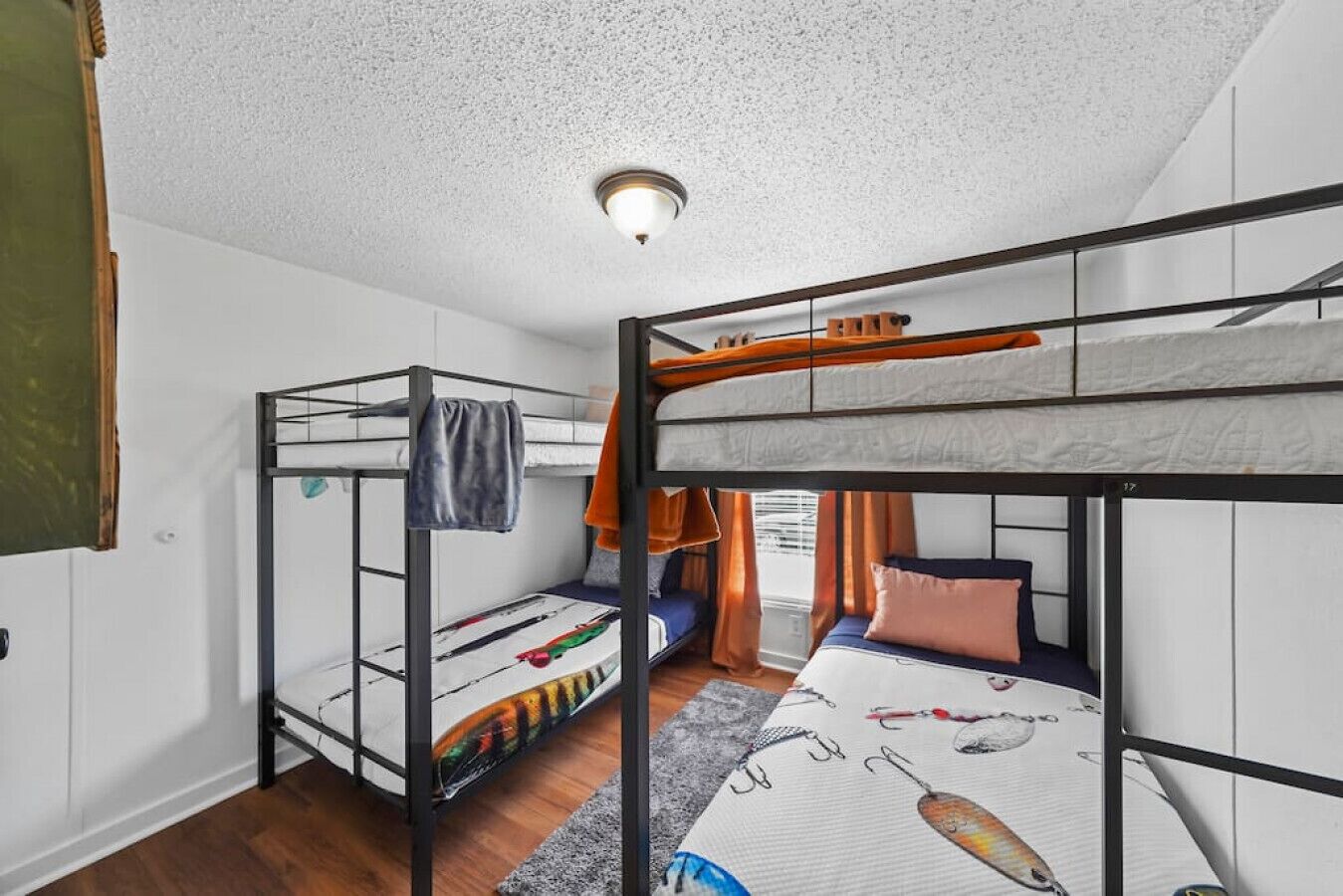 A bunk bed room with a bunk on the left and a single bed on the right.