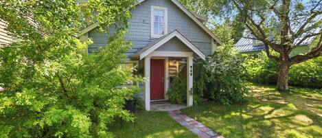 A house with a red door, a small front porch, and a number '17' on the wall.