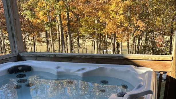 Un jacuzzi con vista a árboles otoñales.