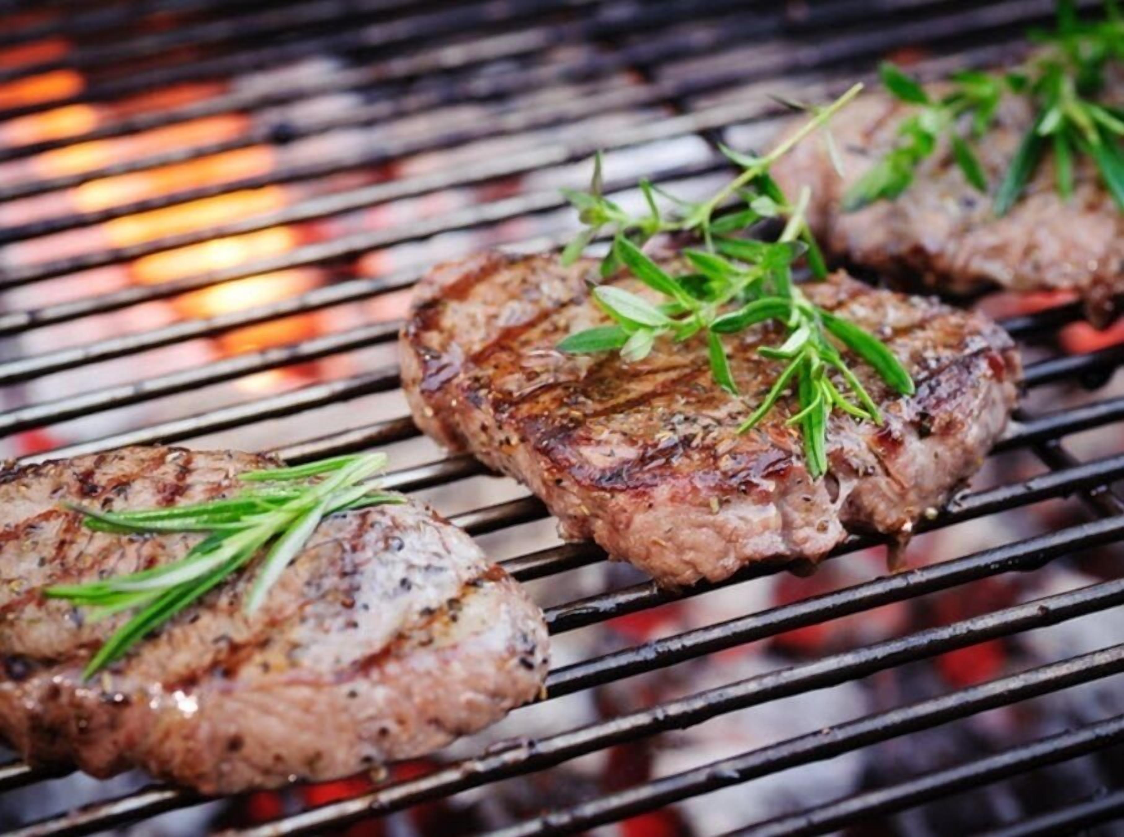 Bistecs en una parrilla con hierbas.