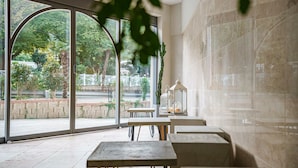 A spacious indoor area with large windows, tables, and chairs arranged for seating. - H.Avenue (Geoje)