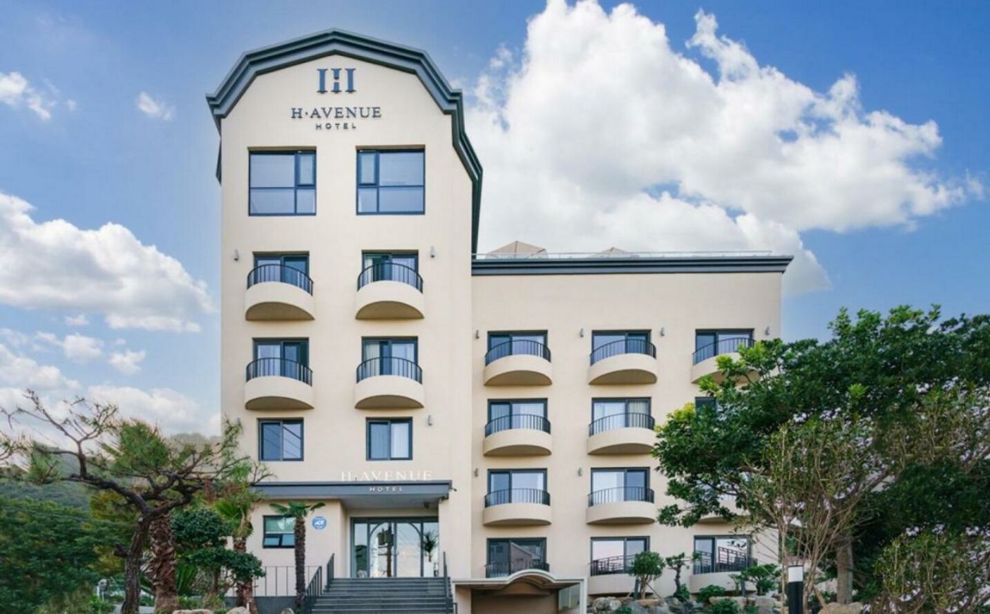 A multi-story hotel with a prominent "Havenue Hotel" sign, multiple balconies, and a well-maintained exterior.
