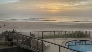 A beach view with a pool and outdoor seating.