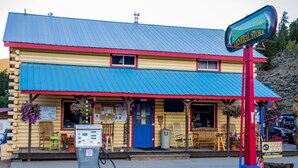 A small, colorful building with a blue roof and a sign that reads "Silver Plume General Store." - Stay in a historical mountain town! (Pitkin)