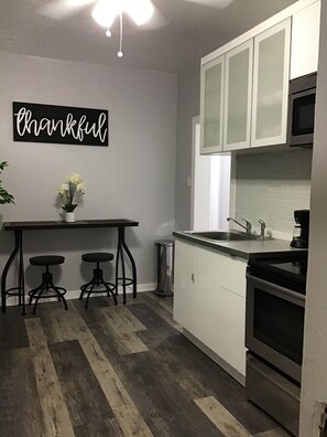 Enjoy cooking in this kitchen with white cabinetry, stainless steel sink, and black oven.
