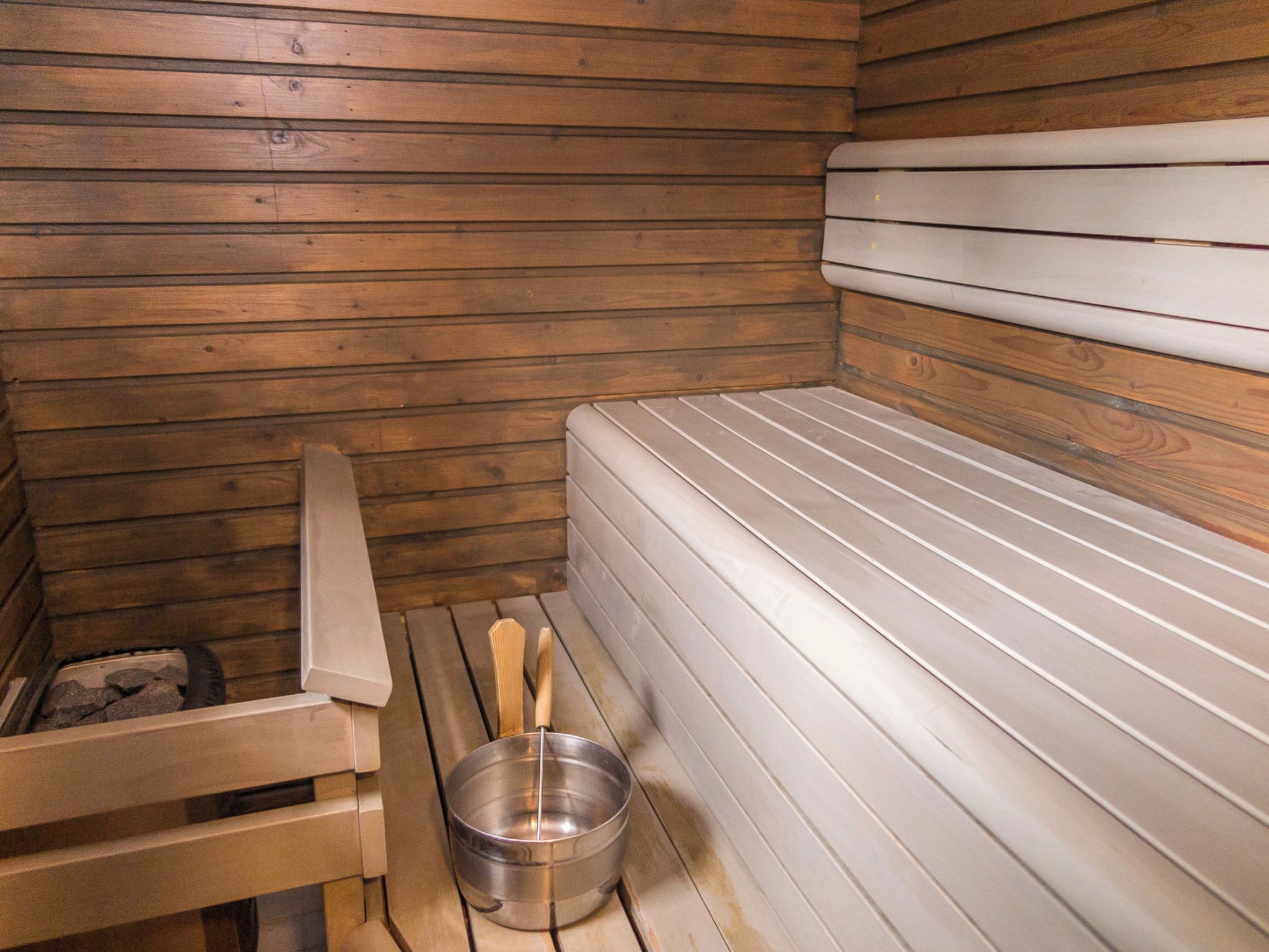 A sauna with wooden walls and a bench.