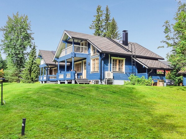 A two-story house with a porch, a chimney, and a well-maintained lawn.