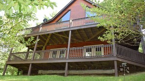 Une cabane en rondins à deux étages, dotée d’un balcon et d’une antenne parabolique.