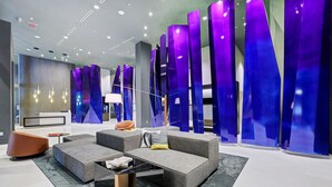 Eine moderne Lobby mit Empfangstresen, Sitzbereich und blauen Dekorationselementen.