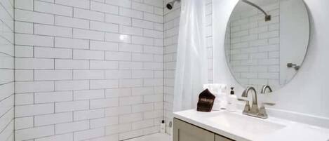 Bathtub, hair dryer, towels, shampoo