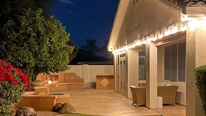 A well-lit patio area with a stone fireplace, outdoor seating, and a grassy lawn. - Comfortable, clean, Spacious, relaxing home in metro-Phoenix area.🌵❤️🏡 (Chandler)
