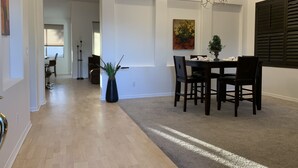 A dining area with a wooden table and chairs, a vase with greenery, and a chandelier. - Comfortable, clean, Spacious, relaxing home in metro-Phoenix area.🌵❤️🏡 (Chandler)