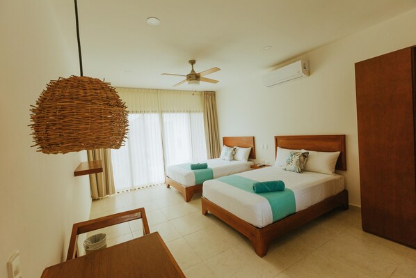 A hotel room with two beds, a ceiling fan, an air conditioning unit, and a large woven light fixture. - Naj Casa Holbox (Isla Holbox)