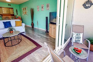 A living room with a sofa, a coffee table, a TV, and a dining area with a table and chairs. - Walk to Lido Beach & Steps to St. Armand's Circle | Heated Pool and Spa | BBQ (Sarasota)