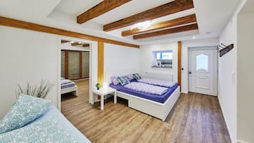 Ein Schlafzimmer mit einem Bett, einem Nachttisch und einem kleinen Fenster.