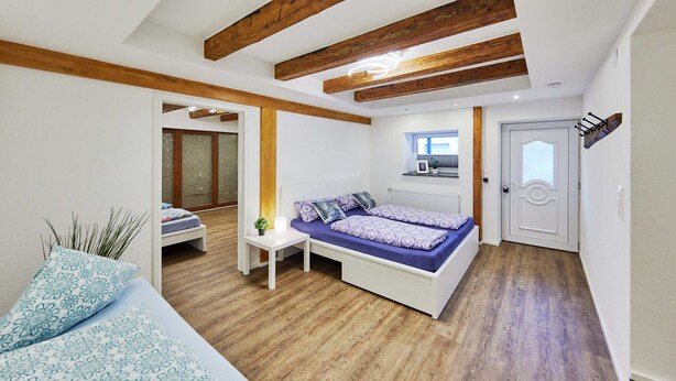 A bedroom with a bed, bedside table, and a small window.