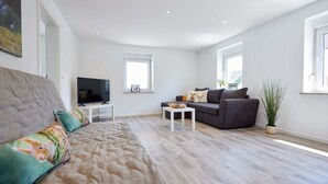 Een moderne woonkamer met een bank, een salontafel en een televisie.