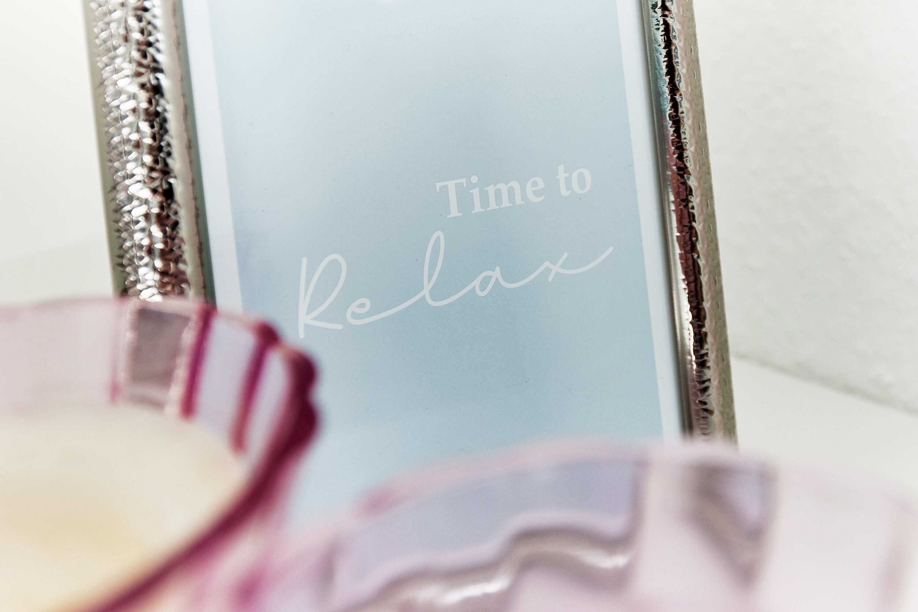 Ein gerahmtes Schild mit dem Schriftzug 'Time to Relax' in einem Badezimmer.