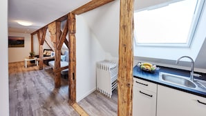 Eine moderne Küche mit Dachfenster, Holzbalken und einer weißen Heizkörper.