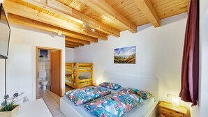 A bedroom with a bed, bedside table, and a view of the bathroom. - Beautiful room perfect for families - only 10 minutes walk from Europa-Park (Rust)