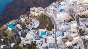 Un pueblo costero con edificios blancos, un acantilado rocoso destacado y vistas al mar.