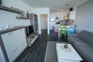 A modern apartment with a living room, kitchen, and dining area.