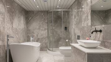 Een aparte badkuip en douche, een diep bad, een haardroger, handdoeken