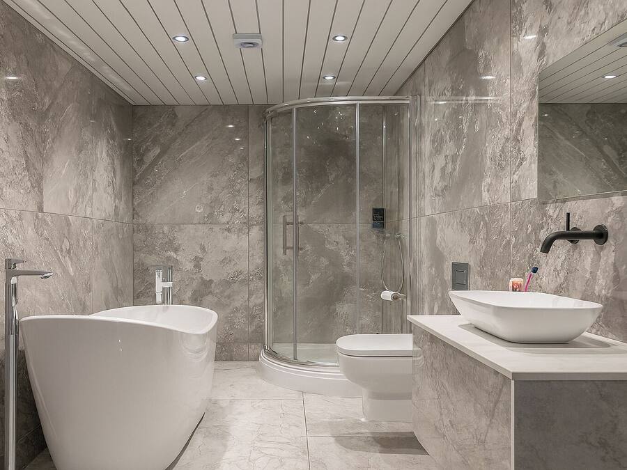 Een aparte badkuip en douche, een diep bad, een haardroger, handdoeken