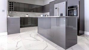 A modern kitchen with sleek cabinetry, a central island, and a built-in oven. - 4 Bed-sleeps 8- Free Parking-pets-hot Tub (Kelty)