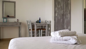 Une chambre d’hôtel avec un lit, un bureau, une chaise et un miroir.
