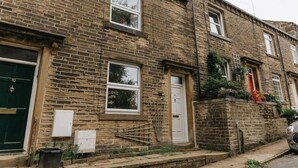 A two-story brick house with a green door, white windows, and a small front garden. - LITTLE RED HOLIDAY HOME // Luxe 2 bed accommodation in Halifax // West Yorkshire (Luddenden)