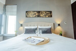 A neatly made bed with a tray, two glasses of water, and a menu on the bed.